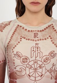 Grafisches T-Shirt mit einem mehrfarbigen abstrakten Muster, aus hellbeigem Stoff mit roten und braunen grafischen Designs und Details am Halsausschnitt.