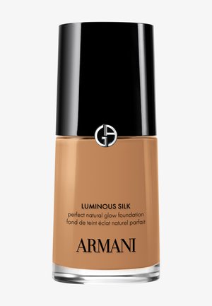 Glassflaske med Armani Luminous Silk foundation, med svart kork, beige væske og trykt hvit tekst med produktdetaljer.