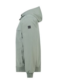 Hellgrüne Jacke mit Kapuze, aus glattem, wasserdichtem Material. Mit elastischen Bündchen, Seitentaschen und einem schwarzen Logo-Patch am Ärmel.