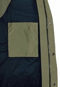 Grüne wasserdichte Jackeninnenseite mit einem marineblauen Futter und einer quadratischen, flachen Tasche auf der linken Seite. Verfügt über einen Reißverschluss und Druckknöpfe.