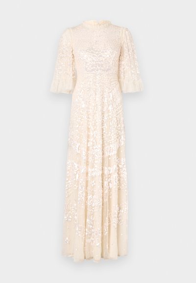 Hosszú krémszínű ruha puffos ujjal, texturált mellrésszel és finoman kidolgozott gyöngyökkel az egész ruha terjedelmében. Laza anyag, elegáns dizájn.