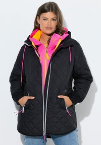 Giacca nera trapuntata con fodera interna rosa e arancione, chiusura frontale con zip e cappuccio regolabile con coulisse a contrasto.