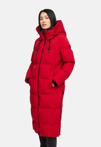 Rød polstret parka-jakke med høj krave, justerbare snore, sidelommer og lynlås foran, med et langt, lige design.