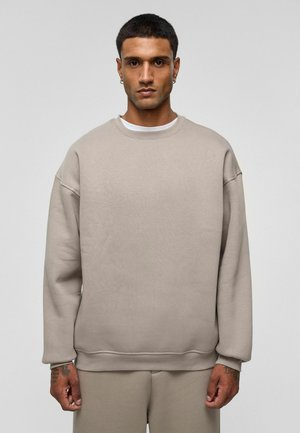 Beige sweatshirt met een ronde hals, verlaagde schouders en geribbelde boorden. Gemaakt van zachte stof, met een eenvoudig, minimalistisch ontwerp.