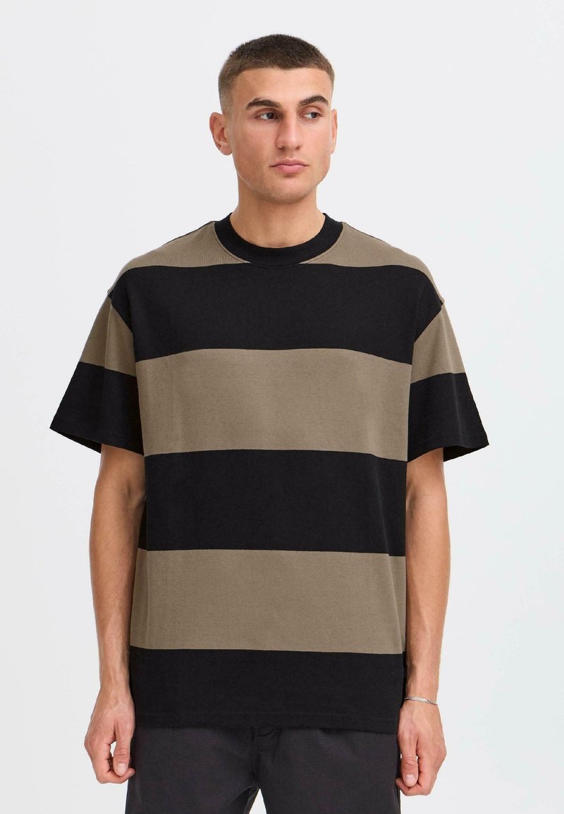 T-shirt rayé vert olive et noir, en coton, avec des manches courtes, un col rond et une coupe décontractée.