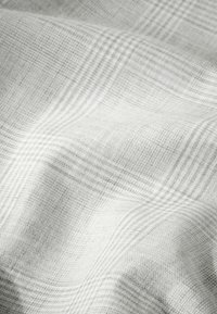 Textile fabric in light gray with a subtle checked pattern. Soft texture with a slight sheen, showing intricate weave details.