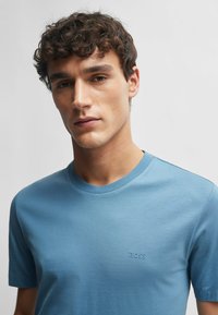 T-shirt azzurro chiaro a maniche corte realizzato in tessuto morbido, con scollatura a girocollo e un piccolo logo in rilievo sul petto.