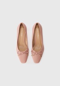 Pink leather ballet flats with a square toe, embellished with a bow and gold accents, featuring a smooth texture and cushioned insole.