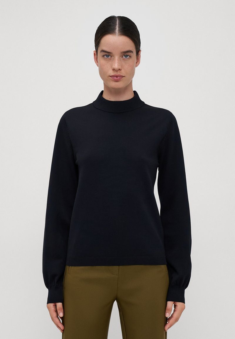 Zwarte gebreide trui met een hoge hals, lange mouwen en geribde manchetten. Glad textuur en slim-fit ontwerp, gecombineerd met olijfgroene broek.