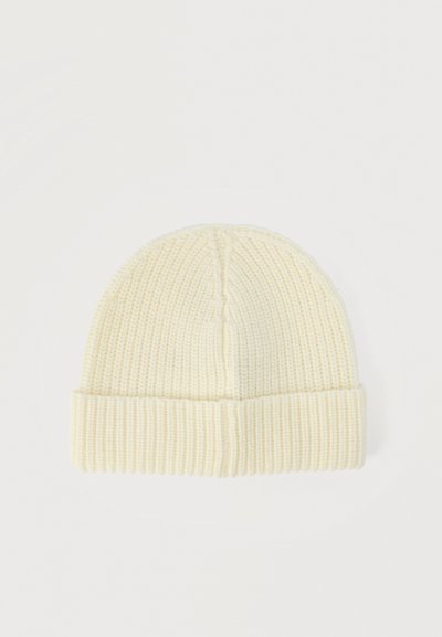 Bonnet en tricot de couleur crème avec revers plié, texture côtelée et détail subtil de maille torsadée sur le dessus.