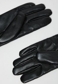 Guanti in pelle nera con una texture liscia, dotati di quattro dita e un pollice, e cuciture per una maggiore struttura.