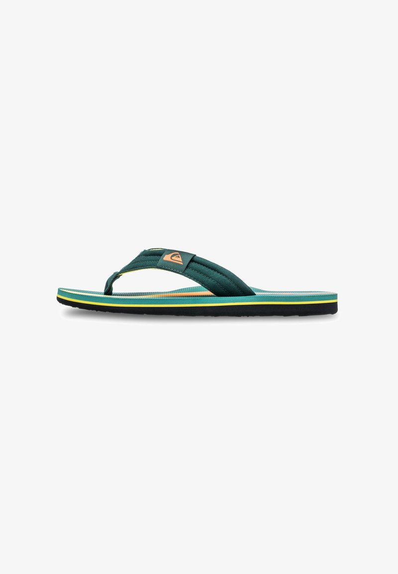 Vihreät kangaspohjaiset flip-flopit, joissa on teksturoitu remmi, kelta-ruskealla ja sinisellä raidallisella pohjalla sekä pieni logotagi remmillä.