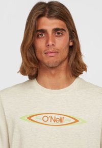 Helle beige Crewneck-T-Shirt mit einem orange- und grünfarbenen Surfbrett-Graphic und "O'Neill"-Text, aus weichem, strukturiertem Stoff gefertigt.