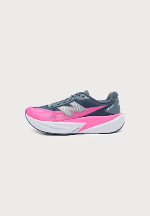 Chaussure de course avec dessus bleu marine et rose vif, logo argenté, semelle blanche et rose rembourrée, et étiquette indiquant "FuelCell" sur le côté.
