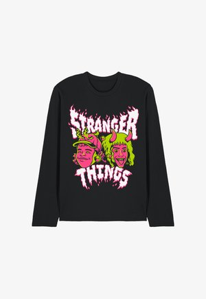 Schwarzes Langarmshirt mit neonpinken und grünen "Stranger Things"-Schriftzug und Cartoon-Gesichtern, die Teufelshörner und Geweih tragen.