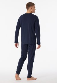 Nachtblaues, langärmliges Pyjama-Set aus weichem Stoff. Das Oberteil hat einen einfachen Rundhalsausschnitt, und die Hose hat einen elastischen Bund.
