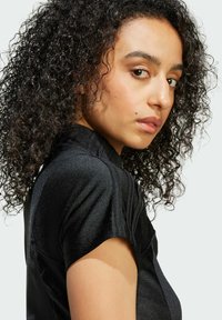 Black, fitted top with a high neckline and short sleeves, featuring a subtle shimmer and ribbed detailing along the shoulders.