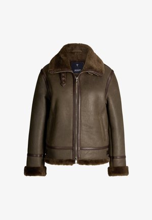 Brązowa skórzana kurtka z kołnierzem z owczej skóry. Posiada frontowy zamek błyskawiczny, boczne kieszenie oraz ciemnobrązowe wykończenia na krawędziach i mankietach.