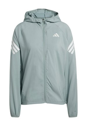 Jasnoszara kurtka z kapturem, wykonana z gładkiego, lekkiego materiału. Posiada białe paski na ramionach oraz zamek błyskawiczny z przodu. Zawiera elastyczne mankiety.