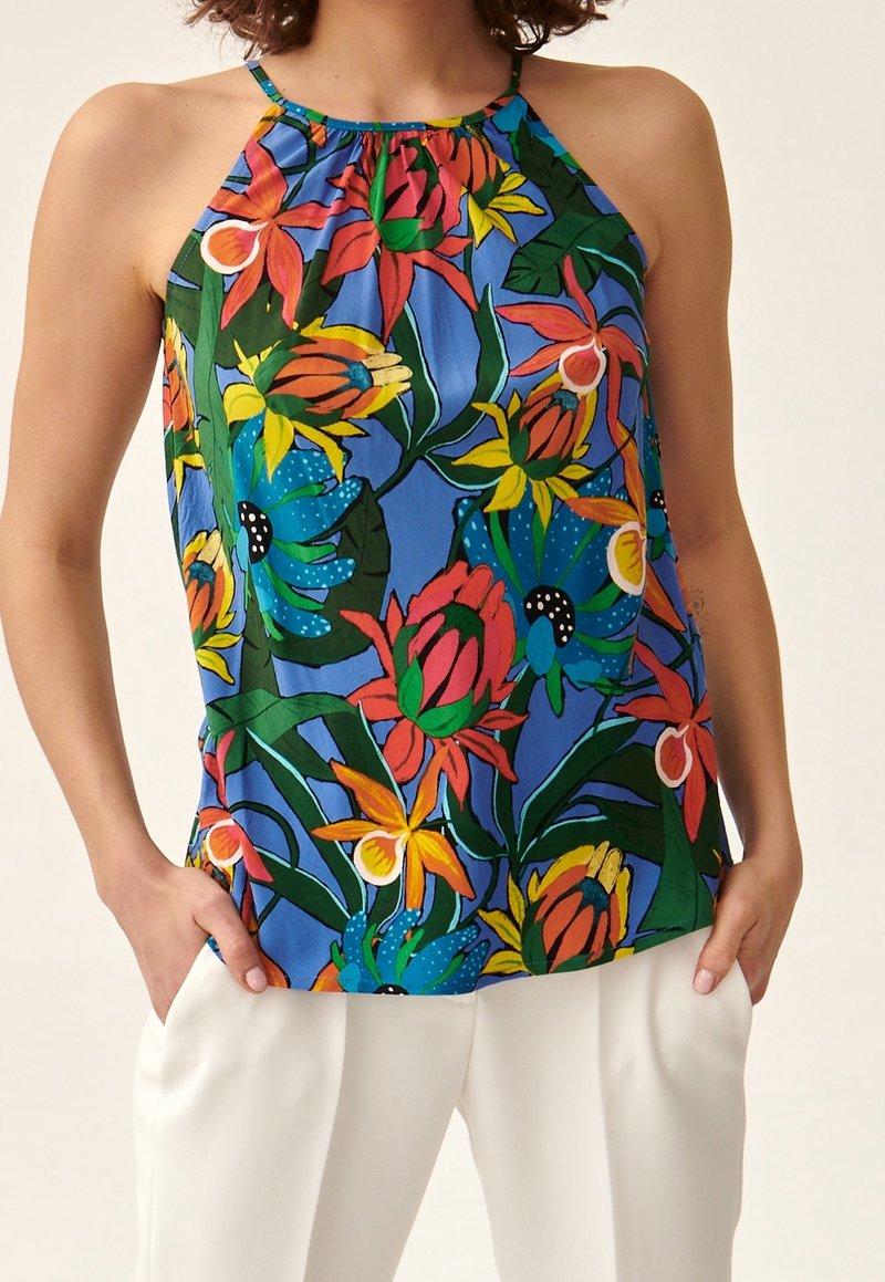 Top a halter con stampa floreale blu, caratterizzato da fiori vivaci in rosso, verde e giallo, con scollo arricciato e vestibilità comoda. Tessuto leggero.