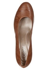 Ballerine plate en cuir marron avec un bout arrondi et une surface lisse. Semelle intérieure métallique avec le nom de la marque ; design minimaliste, sans ornements.