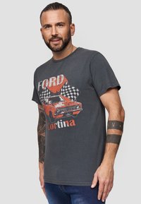 Grå bomulds T-shirt med et rødt Ford Cortina grafik og ternede flag, korte ærmer og en afslappet pasform.