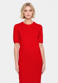 Abito rosso lavorato a maglia con maniche corte, scollatura rotonda e silhouette aderente. Tessuto liscio senza motivi o accenti visibili.