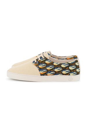 Chaussures basses décontractées avec avant en toile beige et lacets, et tissu multicolore à motifs sur les côtés et le talon. Semelles en caoutchouc blanches.