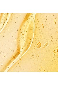 Złocisty płyn z bąbelkami i gładką, błyszczącą teksturą. Posiada zakrzywione fale i przezroczysty wygląd, odbijający światło.