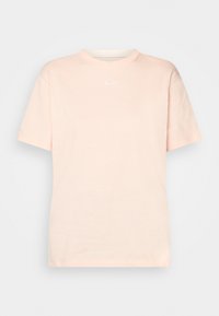 Light peach short-sleeve t-shirt made of cotton, featuring a crew neckline and a small white Nike logo on the chest.