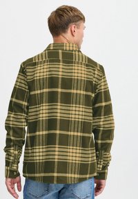 Grøn og beige ternet flannel skjorte med krave, lange ærmer og knaplukninger ved håndleddene. Blød tekstur, lige snit og klassisk mønsterdesign.