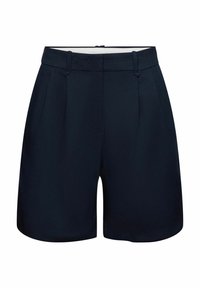Shorts bleu marine ajustés avec passants de ceinture, plis à l'avant et fermeture éclair cachée, présentés sur un fond blanc.