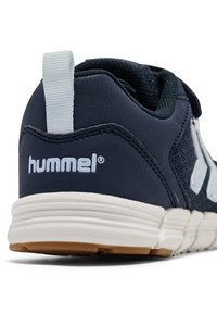 Marine sneaker met bovenwerk van mesh, wit logo en lichte zool. Voorzien van een trekband aan de achterkant en rubberen buitenzool voor grip.