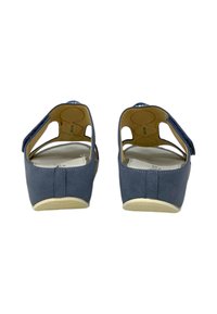 Scarpe slip-on blu con design aperto sul retro, tomaia in tessuto morbido, suola leggera e cinturino regolabile con accenti decorativi.