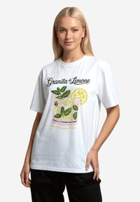 Bílý bavlněný tričko s barevným grafickým motivem nápoje z citronového granity s mátovými listy a plátkem citronu, s textem pod ním.
