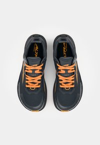 Czarne buty do biegania z pomarańczowymi sznurówkami, siateczkową cholewką, wyściełanym językiem i kołnierzem, odblaskowymi akcentami oraz teksturowaną podeszwą dla lepszej przyczepności.