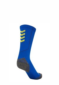 Calcetín azul con puño acanalado, patrón de chevron amarillo y talón gris. Hecho de material suave, diseñado para confort y soporte.