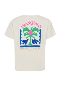 Krémové oversized tričko s živou grafikou rostliny, růžovým kruhem, modrými akcenty a textem: "TRANQUILO, RELAX! VŠECHNO JE V POŘÁDKU."