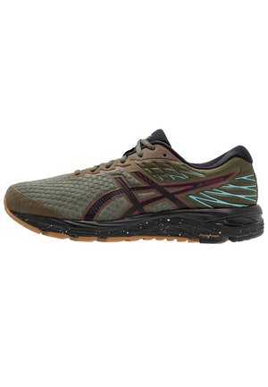 Zapatilla de running verde oliva con detalles en negro y rojo, entresuela negra moteada, suela exterior de goma y acentos azules cerca del talón.
