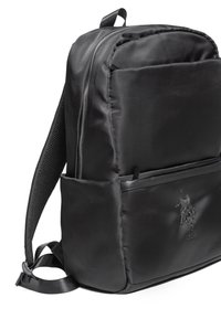 Černý batoh z nylonu s hladkou texturou, zapínáním na zip a přední kapsou s vyraženým logem. Nastavitelné popruhy.