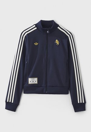 Marineblauwe trainingsjack met witte strepen, ritssluiting, twee zijzakken, geborduurd logo en label met patch aan de zoom. Katoenmix stof.