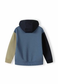 Hoodie s plavim tijelom, crnim rukavima i bež detaljem na ruci. Sadrži rebarčaste manžetne i rub, izrađen je od mekog materijala.
