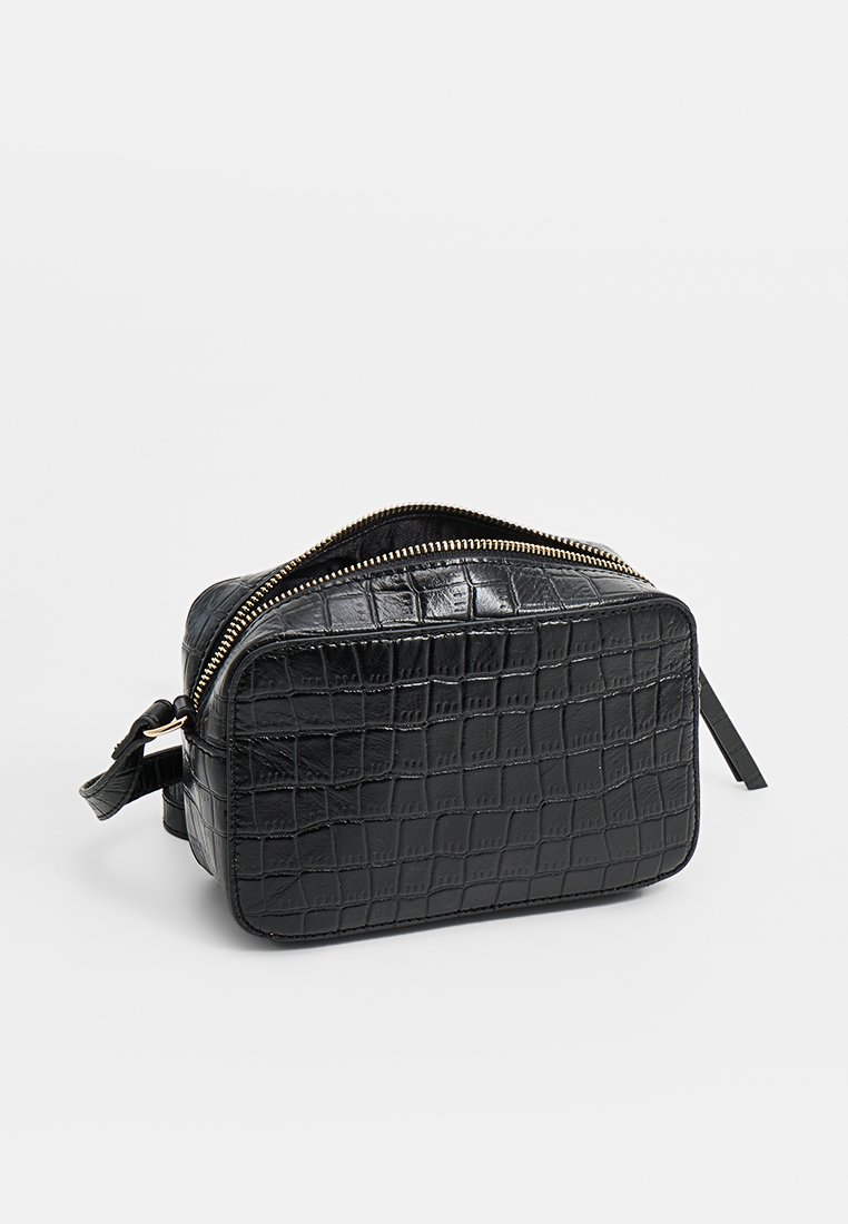 Schwarze, krokodilledergeprägte Tasche mit rechteckiger Form, Reißverschluss oben und einem kleinen Seitengurt zum Tragen. Texturierte Oberflächendetails.