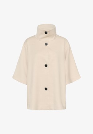 Bežinė trumpa rankovė striukė su aukštu apykakle, kurioje yra penki juodi sagų užsegimai priekyje, pagaminta iš lygaus audinio su subtilia tekstūra.