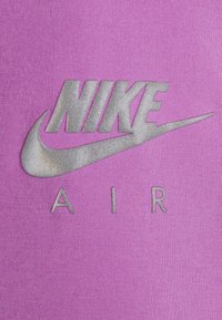 Fialová látka s velkým stříbrným logem Nike nad slovem "AIR," s hladkou texturou a odvážným designem.