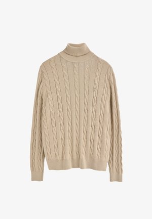Pull en tricot beige avec un col roulé haut et des poignets côtelés, arborant un logo brodé discret sur la poitrine gauche.
