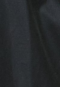 Tecido preto com uma textura suave, apresentando um leve brilho e variações subtis de tonalidade. Sem padrões ou ferragens proeminentes visíveis.