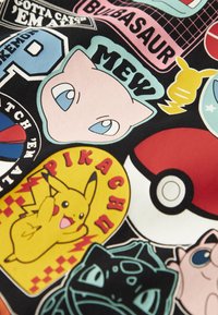 Spalvota medžiaga su įvairiais „Pokémon“ lipdukais, įskaitant geltoną Pikachu, rožinį Mew ir žalią Bulbasaur, juodo fono aplinkoje.