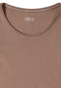 Camiseta marrón de cuello redondo con "CECIL ESSENTIALS" impreso en la parte interior del cuello en la parte posterior.