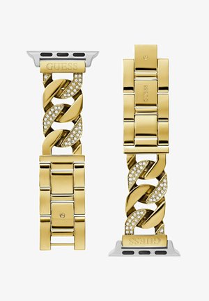 Auksinės spalvos apyrankė su dideliais tarpusavyje susijungusiais žiedais, papuoštais skaidriais kristalais ant tam tikrų žiedų. Sidabrinė užsegimas su „GUESS“ įspaudu.